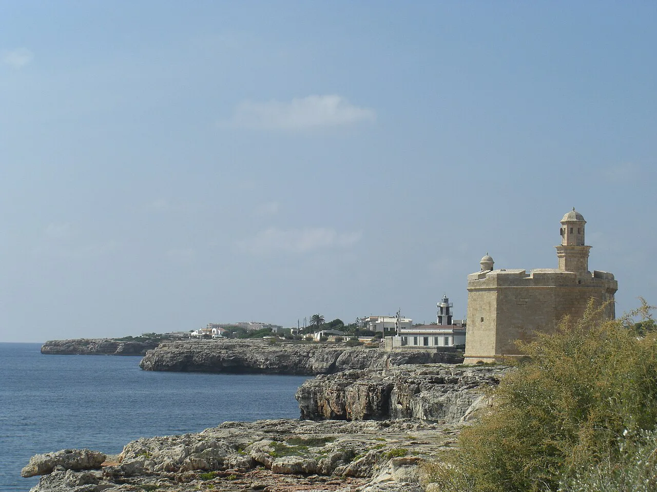 Castell de Sant Nicolau on the rocky shore at the mouth of Ciutadella harbour, Menorca.