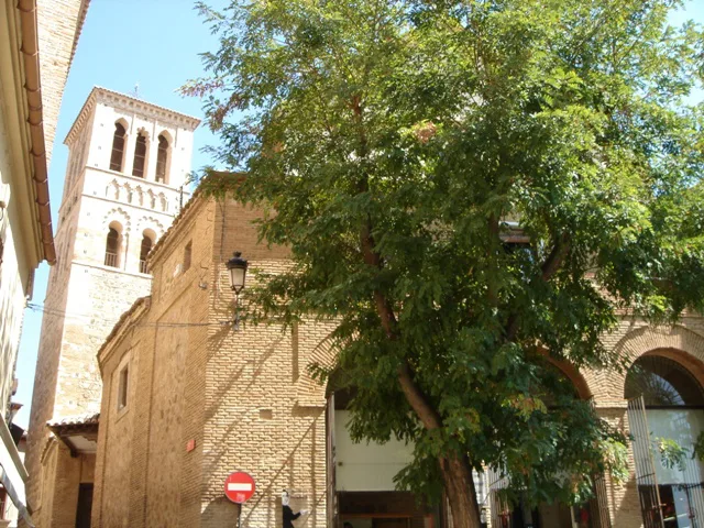 The Mudéjar bell tower of the Iglesia de Santo Tomé rising above a street in Toledo.