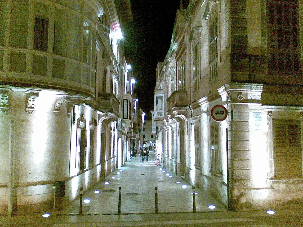 A floodlit street at night in Ciutadella de Menorca.