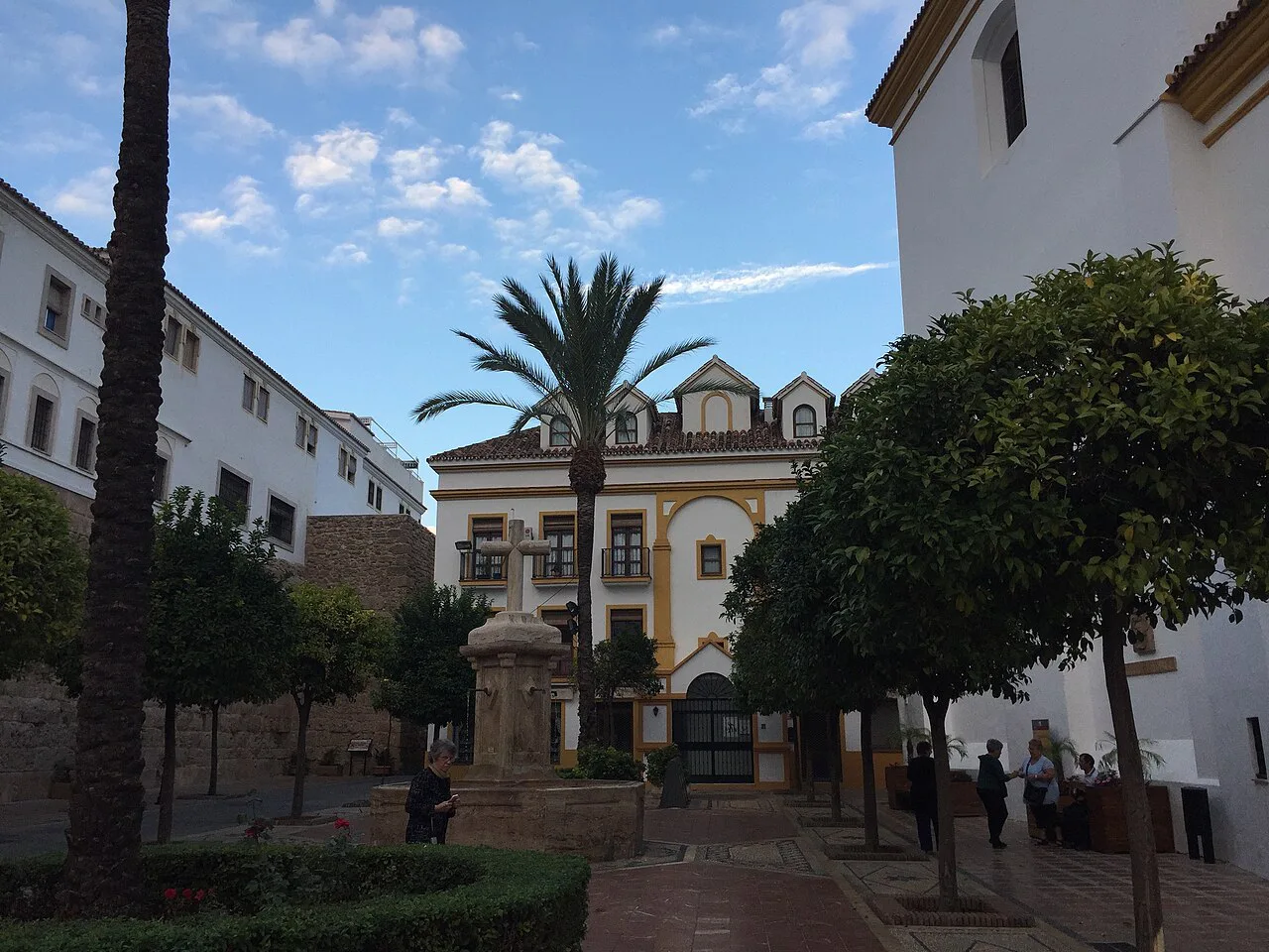 A palm-shaded square with a church in Marbella old town.