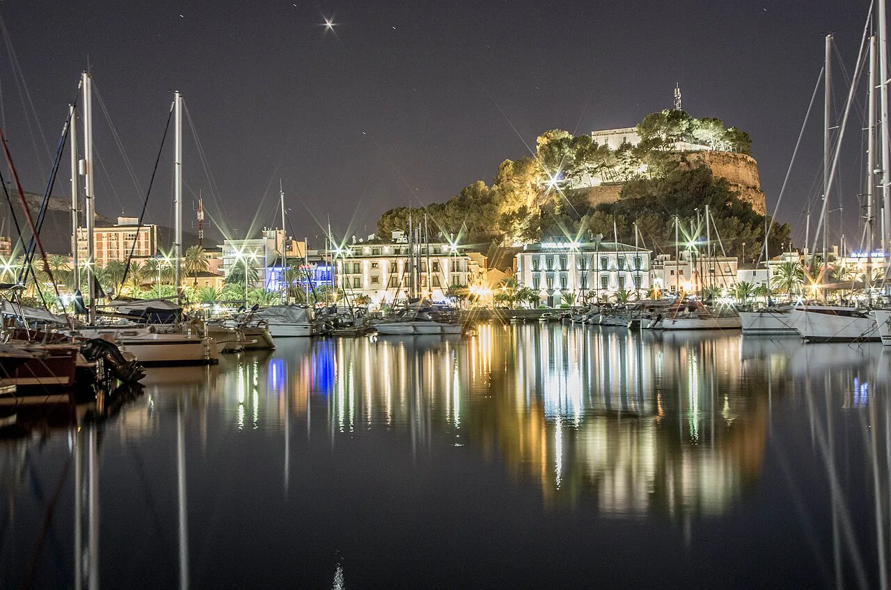 Dénia Castle lit up above the marina at night.