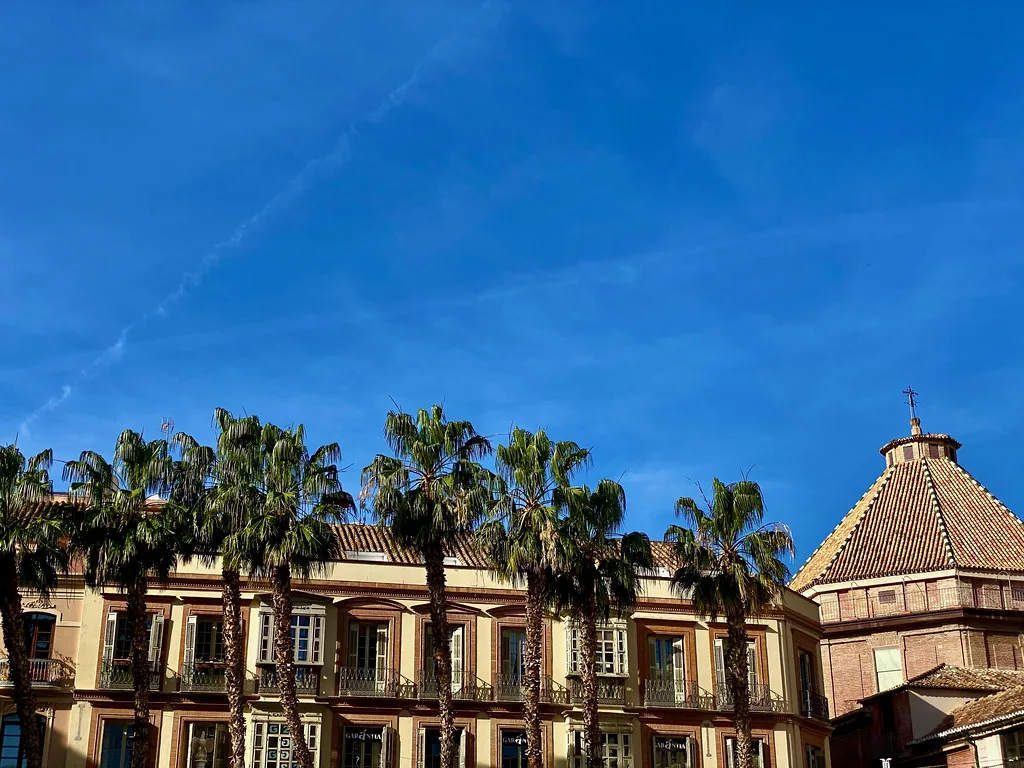 Palm trees and a historic building in Málaga.