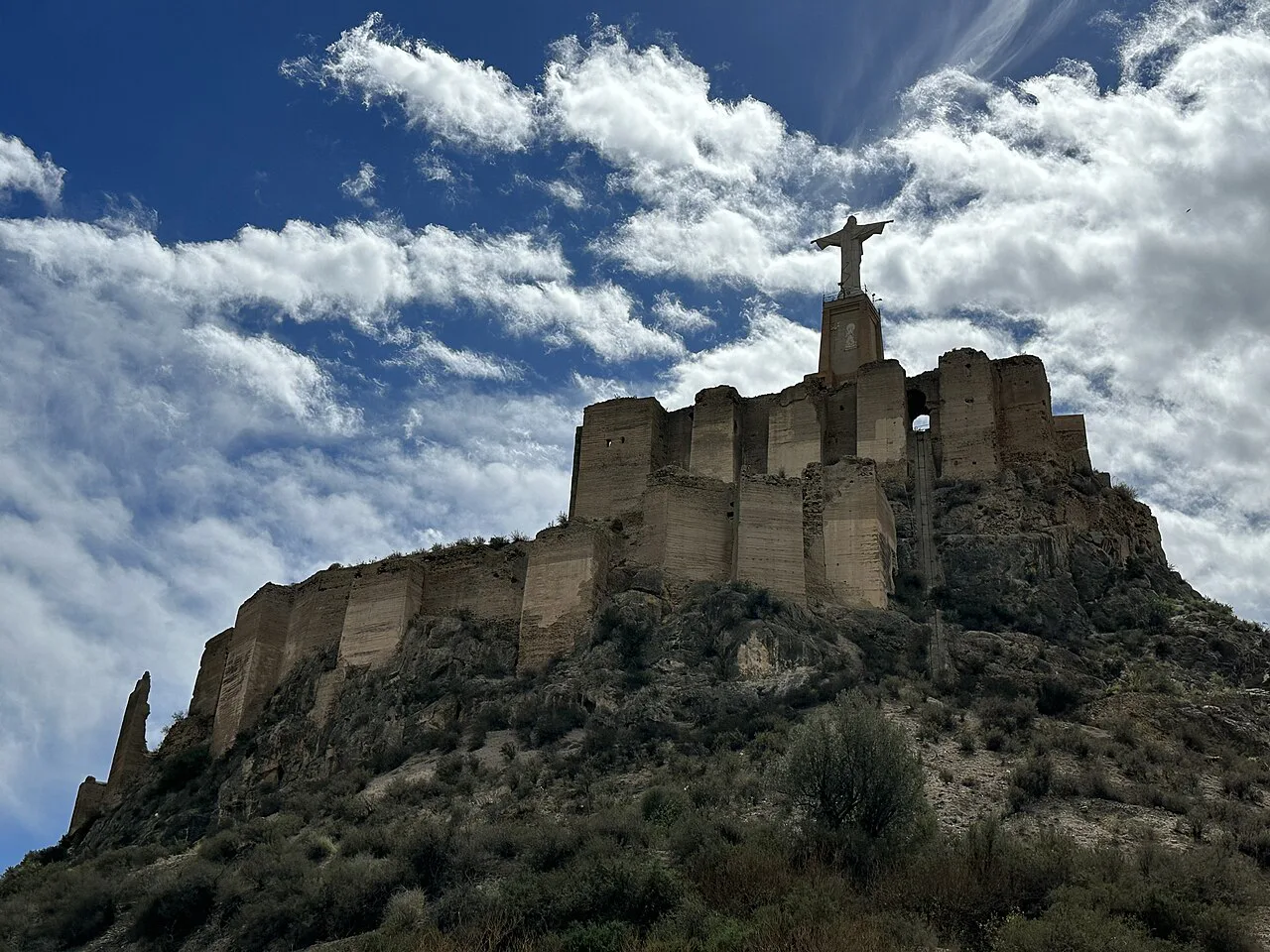 Monteagudo Castle and its Christ statue under a cloudy sky, Murcia.