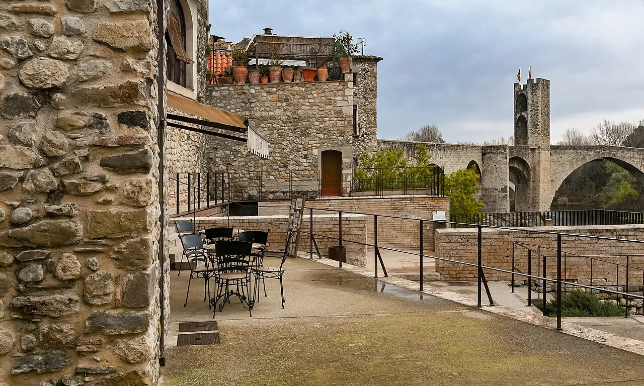 A terrace in Besalú with the medieval bridge in the distance.