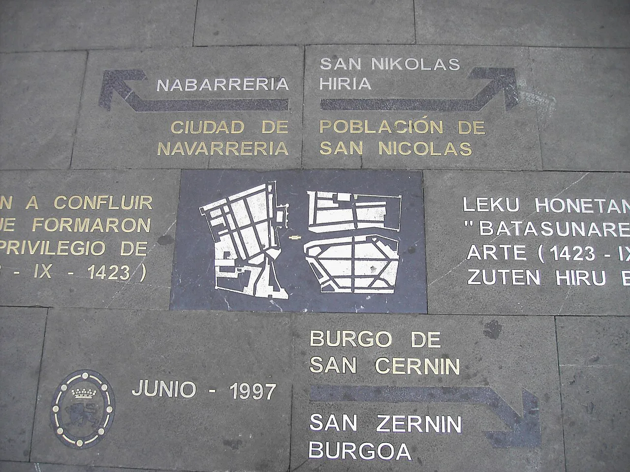 A paving plaque in Pamplona's old town marking the medieval burgos of Navarrería, San Cernin and San Nicolás.