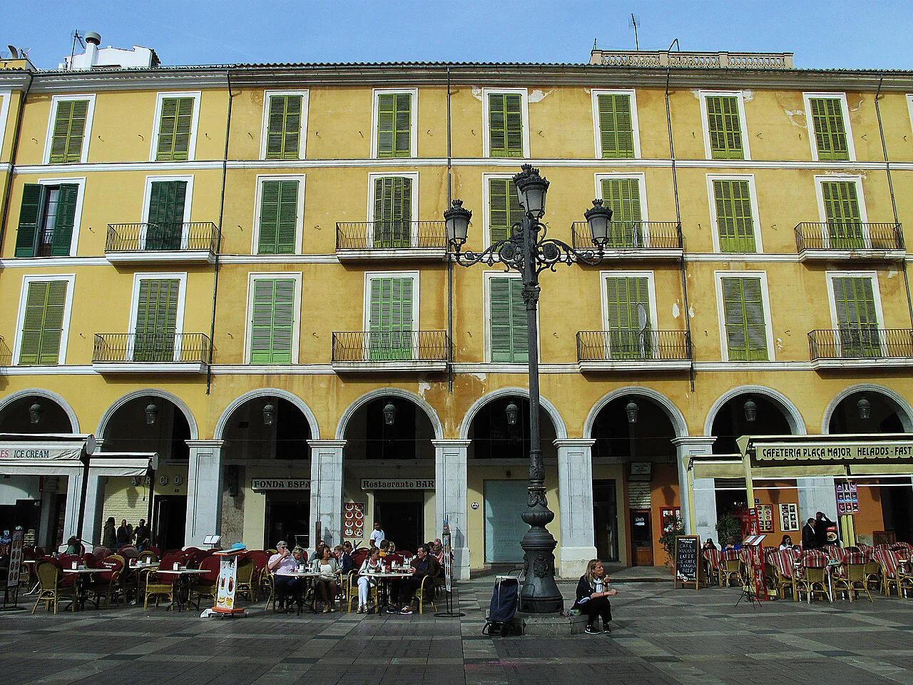 Yellow arcaded façades on the north side of Plaça Major, Palma.