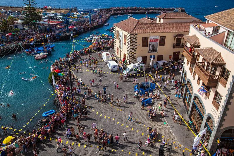 An aerial view of the Plaza del Charco area and harbour in Puerto de la Cruz, crowded with people.
