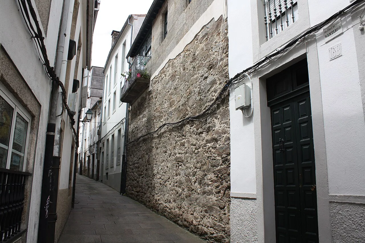 The narrow Rúa Entremuros beside a remnant of the old city wall, Santiago de Compostela.
