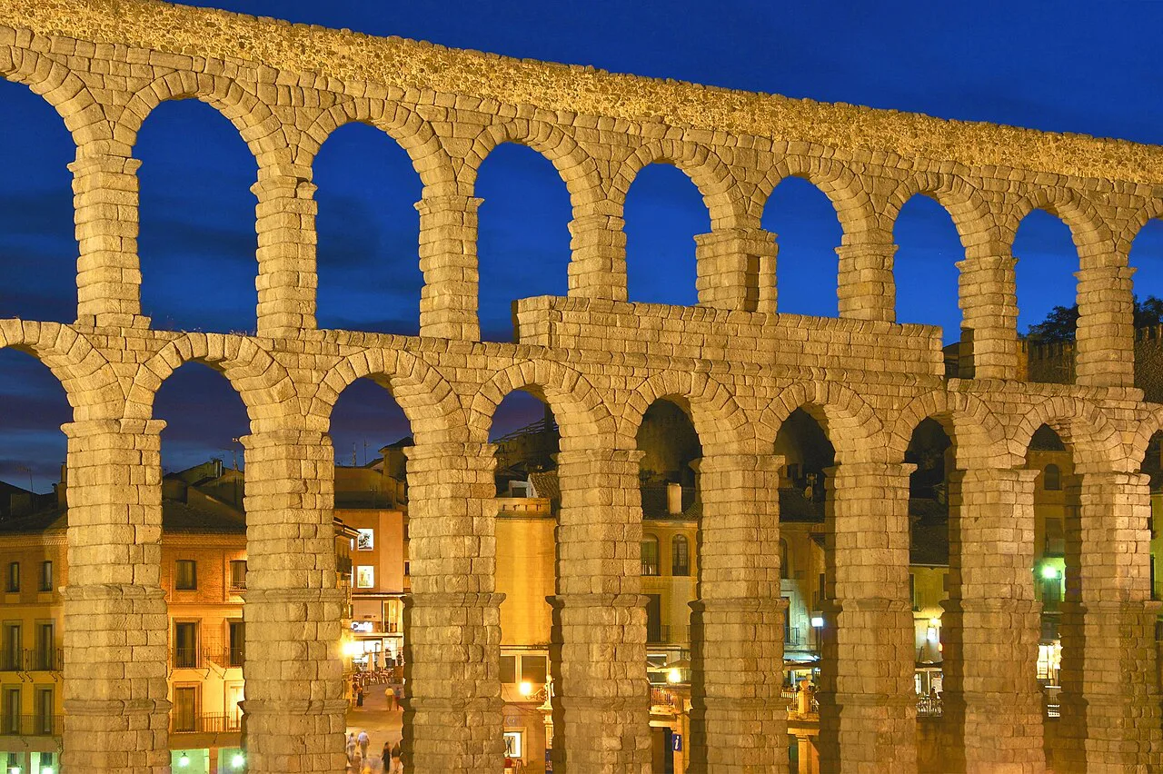 Arches of the Roman Aqueduct of Segovia at dusk.