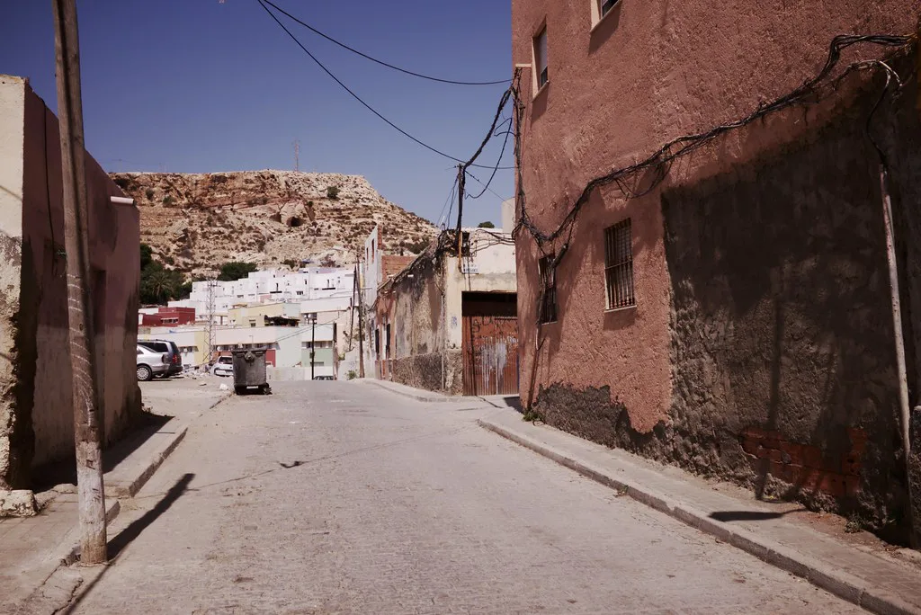 A street in Almería below a hillside of houses.