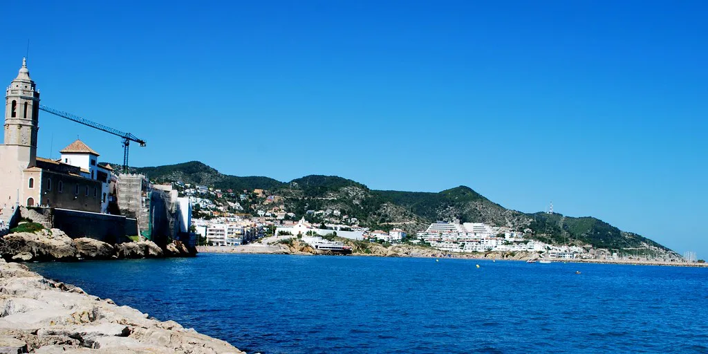The church of Sant Bartomeu i Santa Tecla on its headland and the coast beyond, Sitges.