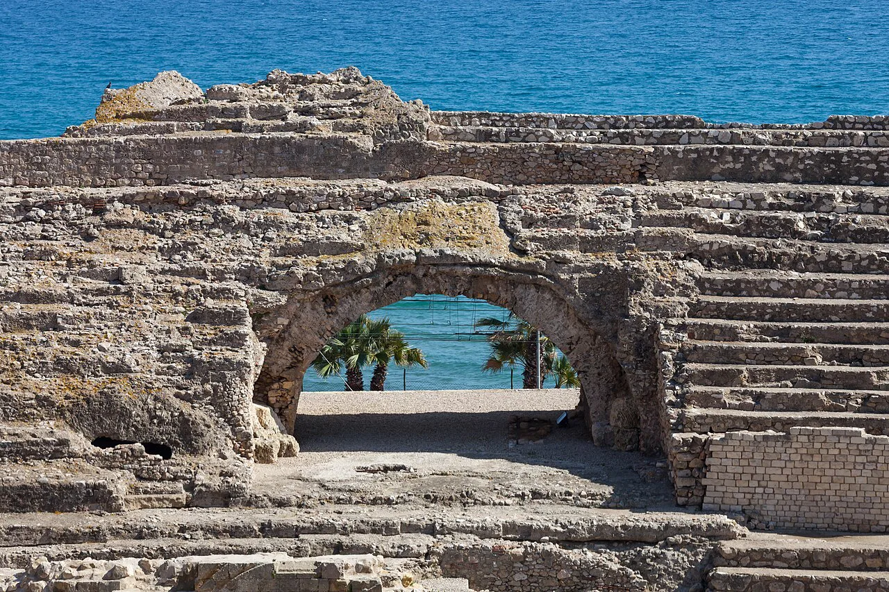An arch of the Tarragona Amphitheatre with the sea beyond.