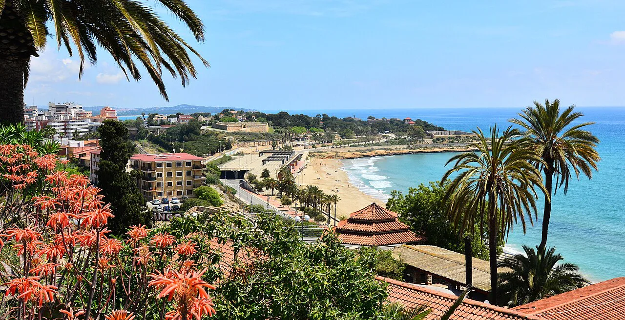 Palms and flowers above the Mediterranean shoreline in Tarragona.