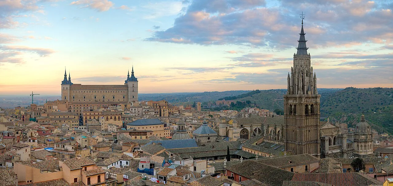 The Toledo skyline with the cathedral tower and the Alcázar at sunrise.