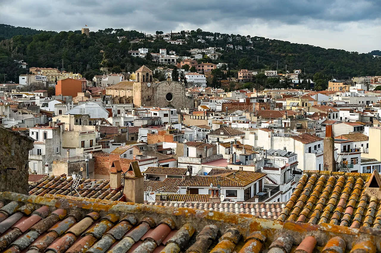 Rooftops of Tossa de Mar below the wooded hills.